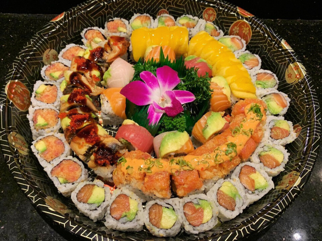 Variety of sushi rolls and sashimi, arranged in a platter at Red Mango Asian Cuisine Restaurant in Stratham