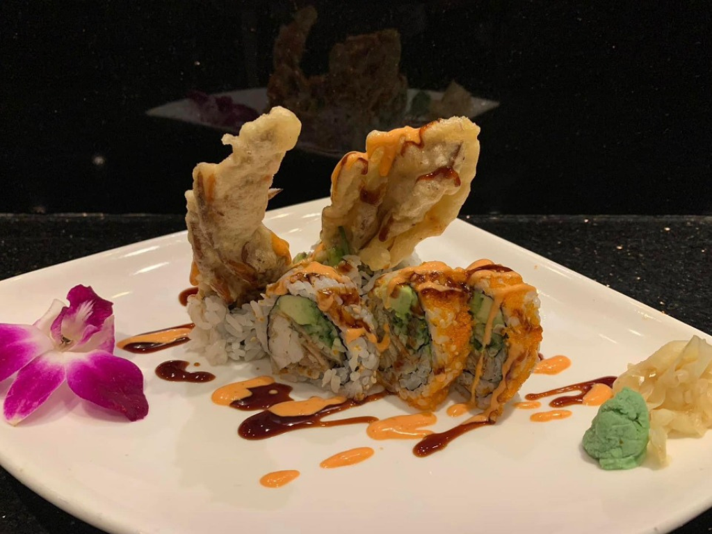 Sushi roll with crispy eel, avocado and sauces, garnished with orchid at Red Mango Asian Cuisine Restaurant in Stratham